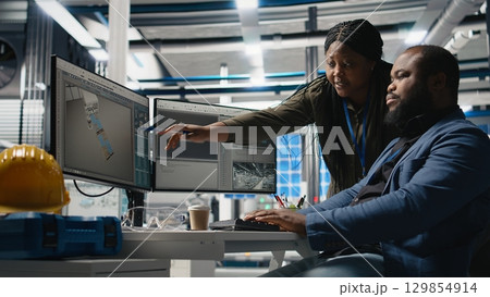 African american industry experts and engineers analyzing solar panel systems during a production inspection, engineering accuracy, quality control and factory operations. Camera A. 129854914