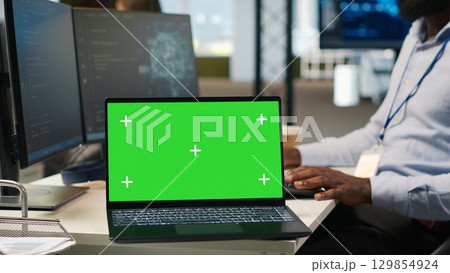 Technician next to office coworkers developing software applications using green screen laptop, integrating AI automation. IT expert debugging applications with mockup notebook, camera A Technician next to office coworkers developing software applications using green screen laptop, integrating AI automation. IT expert debugging applications with mockup notebook, camera A 129854924