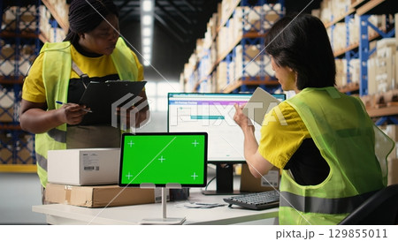Asian employee uses a isolated mockup screen on computer, business software used for supply chain system and package tracking service. Real-time order fulfillment displays. Camera A. 129855011