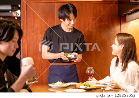 居酒屋 料理を提供する男性スタッフ 居酒屋 料理を提供する男性スタッフ 129855052