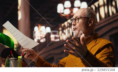 Aged performer engaged in dramaturgy and script practice with lines, demonstrating creativity and discipline during drama rehearsal. Passion for storytelling and reenactment. Aged performer engaged in dramaturgy and script practice with lines, demonstrating creativity and discipline during drama rehearsal. Passion for storytelling and reenactment. 129855108