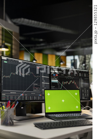 Close up of mockup laptop on desk and computer displaying candlestick graphs with stock market shares. Isolated screen notebook device and PC showing financial data analysis of stock exchange assets Close up of mockup laptop on desk and computer displaying candlestick graphs with stock market shares. Isolated screen notebook device and PC showing financial data analysis of stock exchange assets 129855321