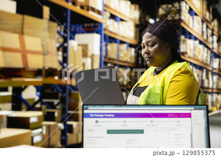 African american depot employee manages a shipping depot with packages ready for delivery. Staff handling inventory and performing quality control, local distribution across the region. African american depot employee manages a shipping depot with packages ready for delivery. Staff handling inventory and performing quality control, local distribution across the region. 129855375
