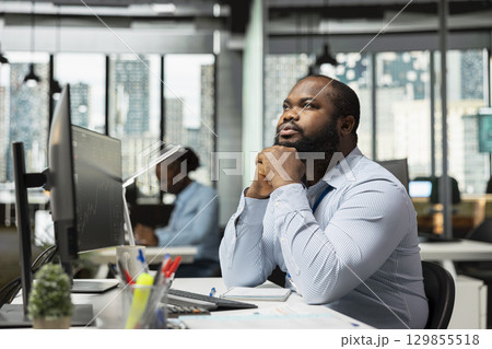 Day trader in office buying and selling stocks quickly to take advantage of market volatility. African american man in prop firm analyzing stock exchange price movements for fast profit opportunities Day trader in office buying and selling stocks quickly to take advantage of market volatility. African american man in prop firm analyzing stock exchange price movements for fast profit opportunities 129855518