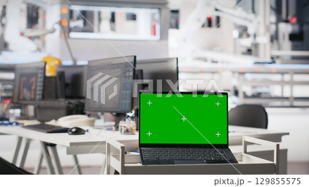 Copy space screen PC in photovoltaics factory used to manage system performance. Chroma key on computer tracking solar panels manufacturing plant energy production and efficiency. 129855575
