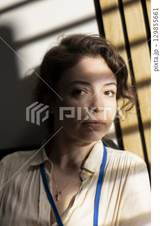 Portrait of confident satisfied woman consultant director with a successful career, posing with elegance next to skyscraper window during golden hour. Beautiful chief closeup. Portrait of confident satisfied woman consultant director with a successful career, posing with elegance next to skyscraper window during golden hour. Beautiful chief closeup. 129855661