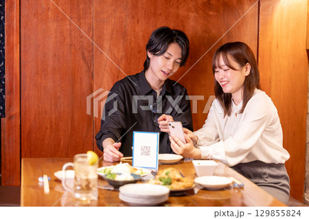 居酒屋　モバイルオーダーで注文する男女 129855824