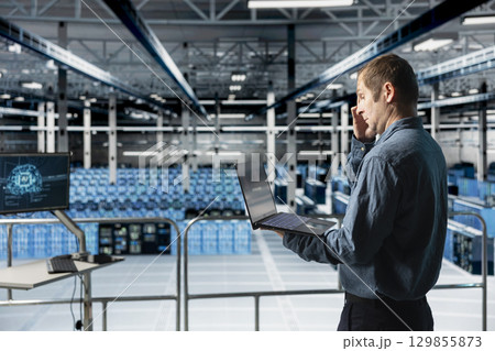 Data center computer scientist reviewing code for AI automation scripts. Server hub IT expert runs neural networks assisted diagnostics on infrastructure for predictive fault detection Data center computer scientist reviewing code for AI automation scripts. Server hub IT expert runs neural networks assisted diagnostics on infrastructure for predictive fault detection 129855873