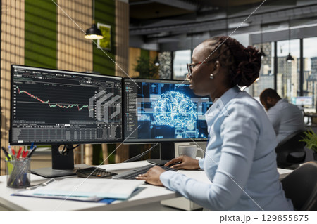 Trader in office using neural network AI models to enhance predictive accuracy of stock market movements. Prop firm employee leveraging artificial intelligence to optimize trading strategies Trader in office using neural network AI models to enhance predictive accuracy of stock market movements. Prop firm employee leveraging artificial intelligence to optimize trading strategies 129855875