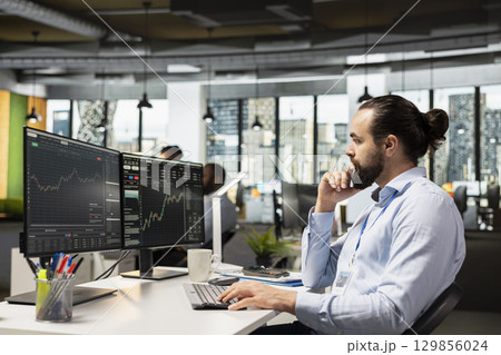 Trader in prop firm office analyzing market data and executing trades using trading software interface on PC. Stockbroker working for asset management company monitoring stock prices using computer Trader in prop firm office analyzing market data and executing trades using trading software interface on PC. Stockbroker working for asset management company monitoring stock prices using computer 129856024