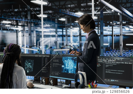 Data center developer monitoring AI systems, adjusting machine learning parameters. Server hub IT employee in office enhancing artificial intelligence software performance Data center developer monitoring AI systems, adjusting machine learning parameters. Server hub IT employee in office enhancing artificial intelligence software performance 129856026