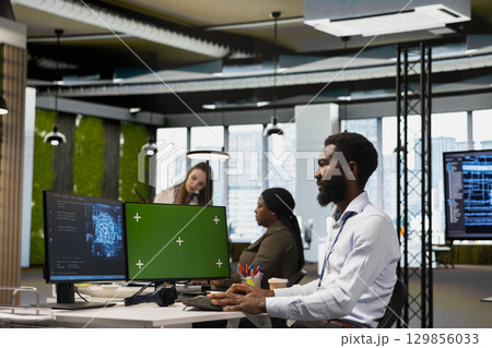 Admin using mockup PC to adjust machine learning algorithms parameters, automating workflow. Tech company worker using AI insights for code optimization on green screen computer 129856033