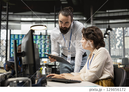 Business associates partners engage in teamwork in a modern workspace, discussing analysis and planning resource allocation to ensure goals achievement. Professional collaboration. 129856172