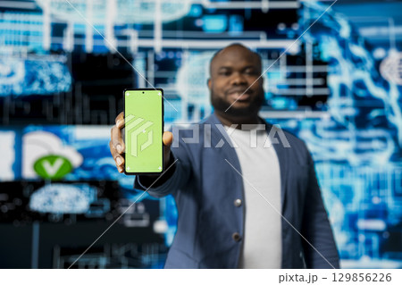 Black businessman using advanced technology and green screen on phone, exploring data science, automation and AI brain in a digital data visualization environment. Machine learning. 129856226