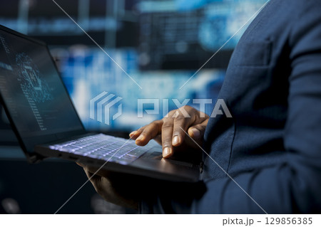 High tech black IT expert working with AI brain data structures environment, illustrating computer science and automation tools for machine learning. Implementing neural networks systems. 129856385