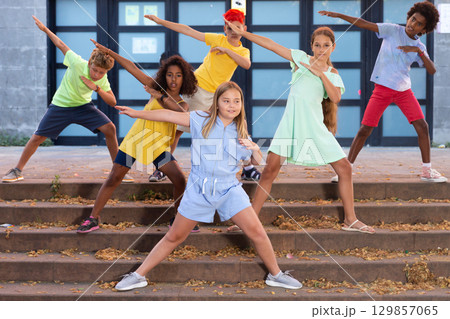 Children exercising contemporary dance moves outdoors 129857065