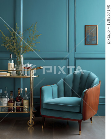 Plush teal armchair placed near glamorous brass bar cart stocked with drinks, creating luxurious, relaxing interior scene perfect for sophisticated evening 129857140
