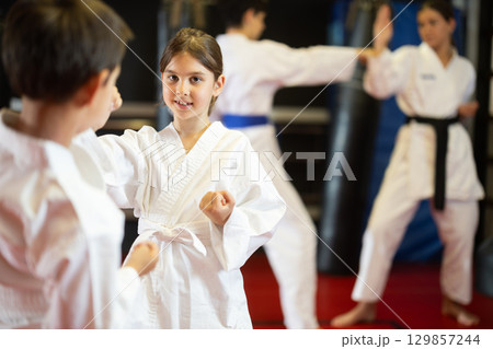 Boy and girl practice karate in pairs 129857244
