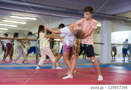 Kids learning self-defence moves in gym 129857266