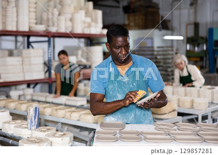 Ceramist polishing new clay plates Ceramist polishing new clay plates 129857281