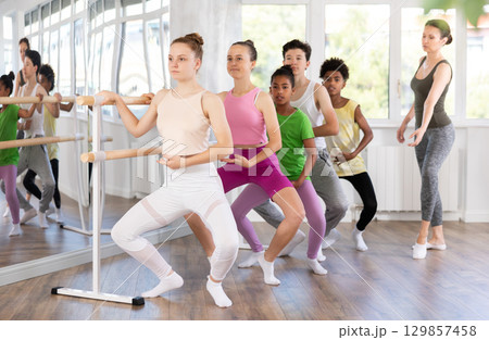 Teenage girl practicing plie position of ballet during choreography classes 129857458