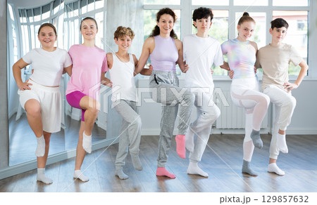 Boys and girls teenagers choreography students perform Irish dance with female teacher 129857632