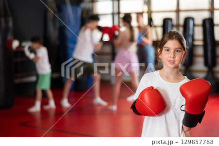 Teenage girl in boxing gloves in training Teenage girl in boxing gloves in training 129857788