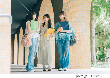 キャンパスを歩く3人の女子大学生 キャンパスを歩く3人の女子大学生 129858302