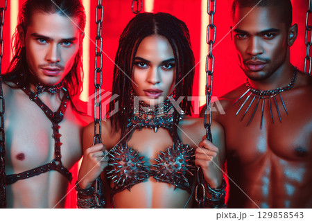 Sexy mistress woman with two submissive men in chains. BDSM sex with submission and domination 129858543