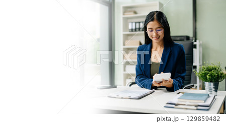 Asian woman sitting at a desk using a laptop computer Navigating Finance and Marketing Asian woman sitting at a desk using a laptop computer Navigating Finance and Marketing 129859482