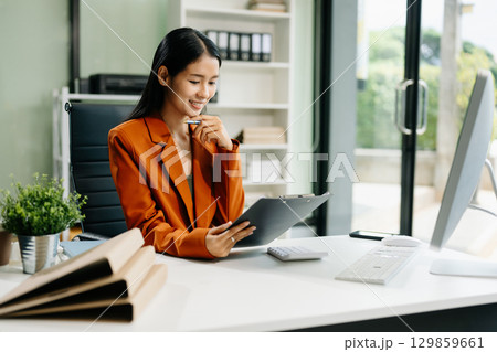 Asian woman sitting at a desk using a laptop computer Navigating Finance and Marketing Asian woman sitting at a desk using a laptop computer Navigating Finance and Marketing 129859661