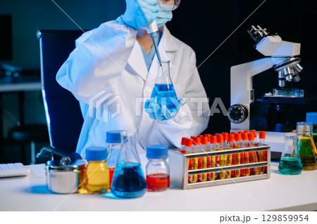 Scientists, beakers, and microscopes in cutting-edge research. Perfect for science and technology projects. 129859954