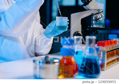 Scientists, beakers, and microscopes in cutting-edge research. Perfect for science and technology projects. 129859955
