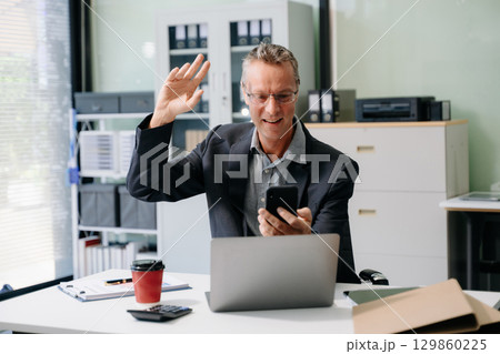 Mature business man executive manager looking at laptop watching online webinar training or having virtual meeting Mature business man executive manager looking at laptop watching online webinar training or having virtual meeting 129860225