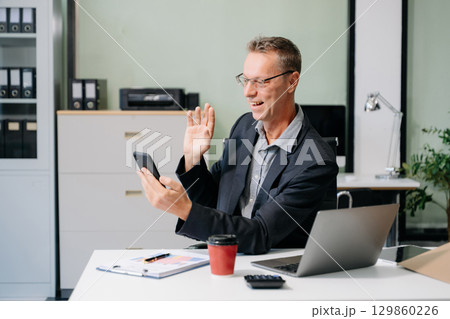 Mature business man executive manager looking at laptop watching online webinar training or having virtual meeting 129860226