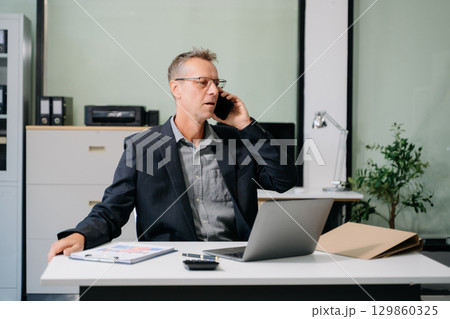 Professional businessman working at office with laptop, tablet, and notes. Perfect for business, finance, accounting 129860325