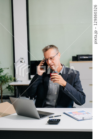 Mature business man executive manager looking at laptop watching online webinar training or having virtual meeting 129860326