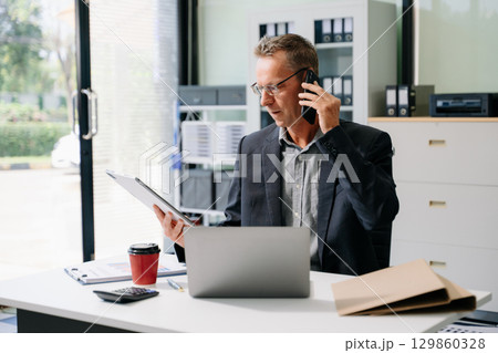 Mature business man executive manager looking at laptop watching online webinar training or having virtual meeting 129860328