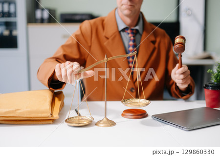 justice and law concept. Male judge in a courtroom the gavel, working with smart phone and laptop justice and law concept. Male judge in a courtroom the gavel, working with smart phone and laptop 129860330