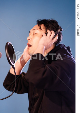 ボイストレーニングをしてレコーディングする若い男性 129860549