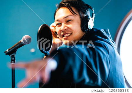 ボイストレーニングをしてレコーディングする若い男性 129860558