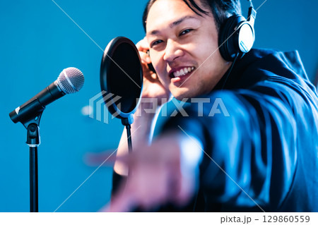 ボイストレーニングをしてレコーディングする若い男性 129860559
