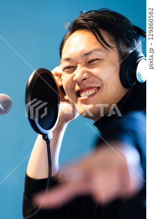 ボイストレーニングをしてレコーディングする若い男性 ボイストレーニングをしてレコーディングする若い男性 129860562