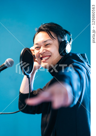 ボイストレーニングをしてレコーディングする若い男性 129860563
