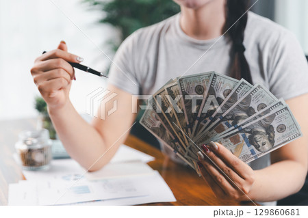 Business, finance and employment, entrepreneur and money concept. Successful young asian office manager, businesswoman showing earned cash, satisfied holding dollars, money dollar bills 129860681