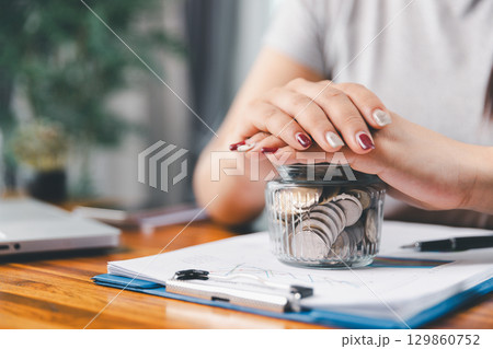 Young Asian woman making stack of coin. invest save finance concept, saving money, investment. dollar bills on table with pile of coins and banks calculator, money to save and invest to make income. Young Asian woman making stack of coin. invest save finance concept, saving money, investment. dollar bills on table with pile of coins and banks calculator, money to save and invest to make income. 129860752