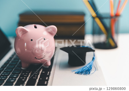 Concept of saving money for education, student loan, scholarship in future. Piggy bank with graduation hat, stack of coins. Earth globe with graduation hat, dollar banknotes on table. Tuition fees Concept of saving money for education, student loan, scholarship in future. Piggy bank with graduation hat, stack of coins. Earth globe with graduation hat, dollar banknotes on table. Tuition fees 129860800