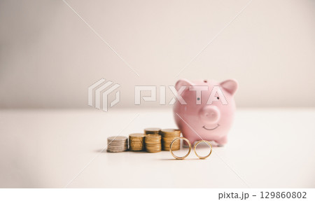 Save money for wedding and planning wedding concept. Sustainable financial goal for family life or married life. Miniature wedding on rows of rising coins, depicts savings or growth for new family. Save money for wedding and planning wedding concept. Sustainable financial goal for family life or married life. Miniature wedding on rows of rising coins, depicts savings or growth for new family. 129860802