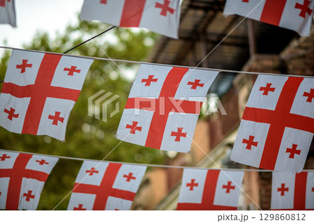 Georgian flags hanging outdoors with blurred background in Old Town in Tbilisi, Georgia Georgian flags hanging outdoors with blurred background in Old Town in Tbilisi, Georgia 129860812