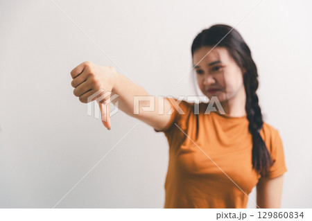 Asian girl expresses dislike, person express negative feeling, concept business complaint from customer ensuring employee satisfaction negative feedback to prevent mental strain customer dislike 129860834